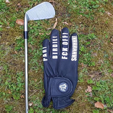 A Glove And Golf Club Laying On The Ground