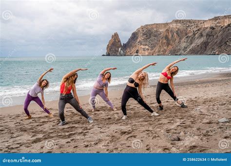 A Group Of Five Female Friends Are Doing Exercises On The Beach Beach Holiday Concept Healthy