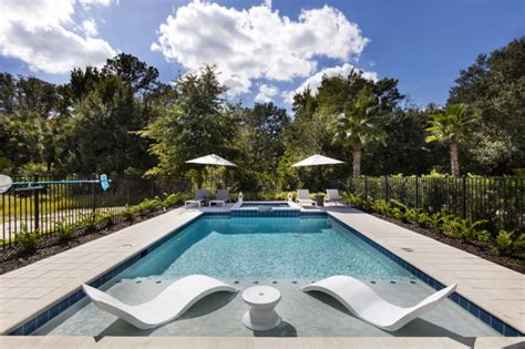 A Large Indoor Swimming Pool With Sun Loungers And Tables Next To It