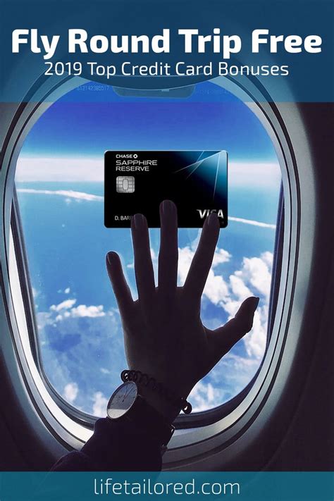 A Person S Hand Holding Up A Credit Card In Front Of An Airplane Window