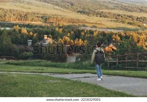 A Person With A Backpack Walking On Top Of A Hill In The Mountains And