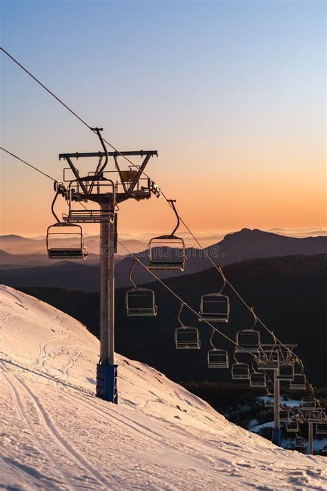 A Ski Lift Going Up The Side Of A Snow Covered Mountain With A Sky