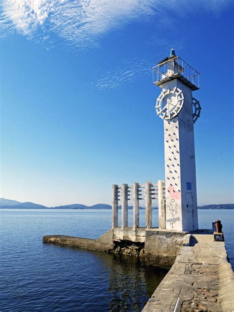 An Old Tower Sitting On Top Of A Pier Next To The Ocean