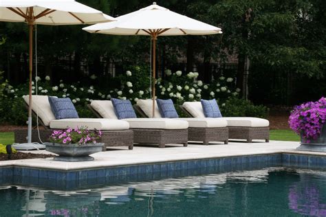 An Outdoor Patio With Chairs Table And Pool In Front Of A Building