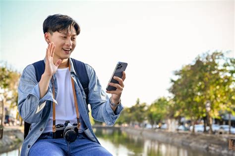 Handsome And Happy Young Asian Male Traveler Video Call With His