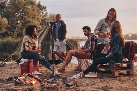 Happy To Travel Together Group Of Young People In Casual Wear Smiling And Drinking Beer While