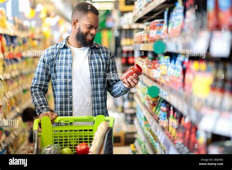 Man Doing Grocery Shopping Standing With Cart Choosing Food Indoors Stock Photo Alamy