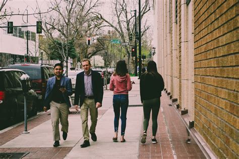 People Are Walking Down The Street In Front Of Buildings