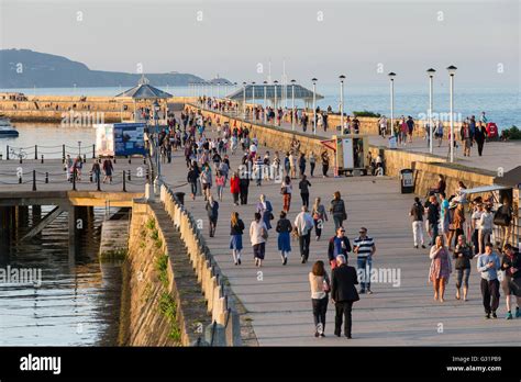 People Are Walking On The Pier Near Some Buildings