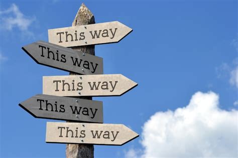 Premium Photo This Way Wooden Signpost With Five Arrows Sky With Clouds