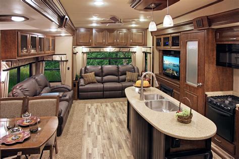 The Interior Of An Rv With Couches Kitchen And Living Room Area In It