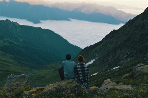 Two People Sitting On Top Of A Mountain With The Words Best Family