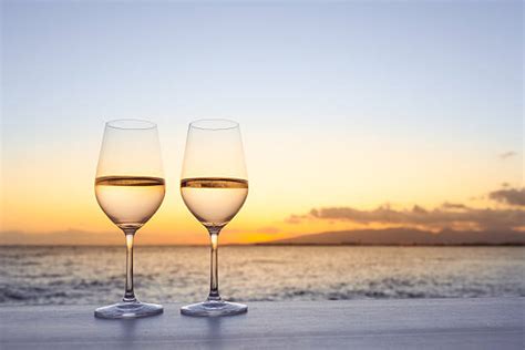 Two Pictures With Wine Glasses On The Table And An Ocean View In The