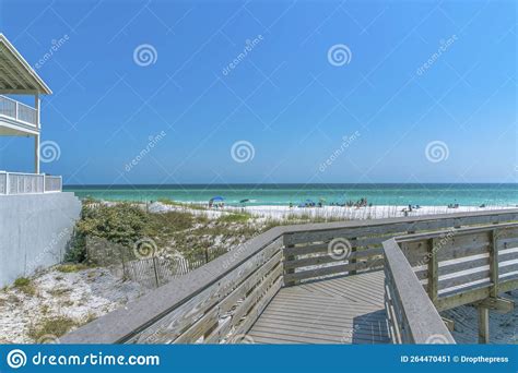 View Of The Beach With Tourists On The Shore From A Boardwalk At Destin